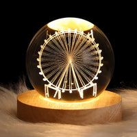Leuchtende Kristallkugel mit Riesenrad-Design auf Holzsockel, dekorative LED-Lampe.