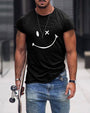 Mann mit schwarzem T-Shirt mit Smiley-Design, Jeans, Skateboard, urbaner Hintergrund.