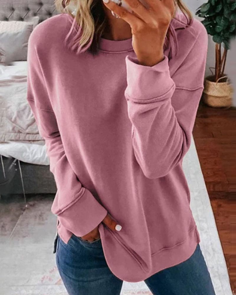 Frau in rosa Sweatshirt, lässig, gemütlich, modisch, Freizeitkleidung, Wohnzimmer, Jeans.