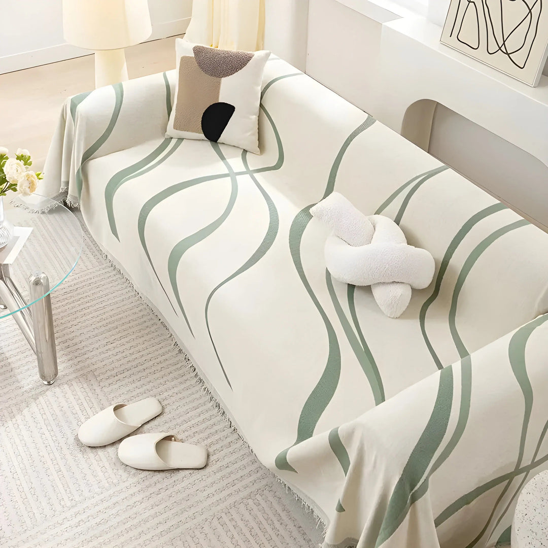 Beige Sofa mit grünem Wellenmuster, dekoriert mit Kissen, im modernen Wohnzimmer.