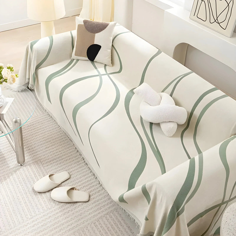 Beige Sofa mit grünem Wellenmuster, dekoriert mit Kissen, im modernen Wohnzimmer.