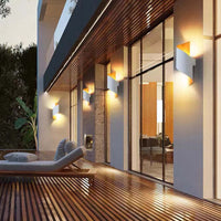 Moderne Außenwandleuchten an Hausfassade, warmweißes Licht, zeitgenössisches Design.