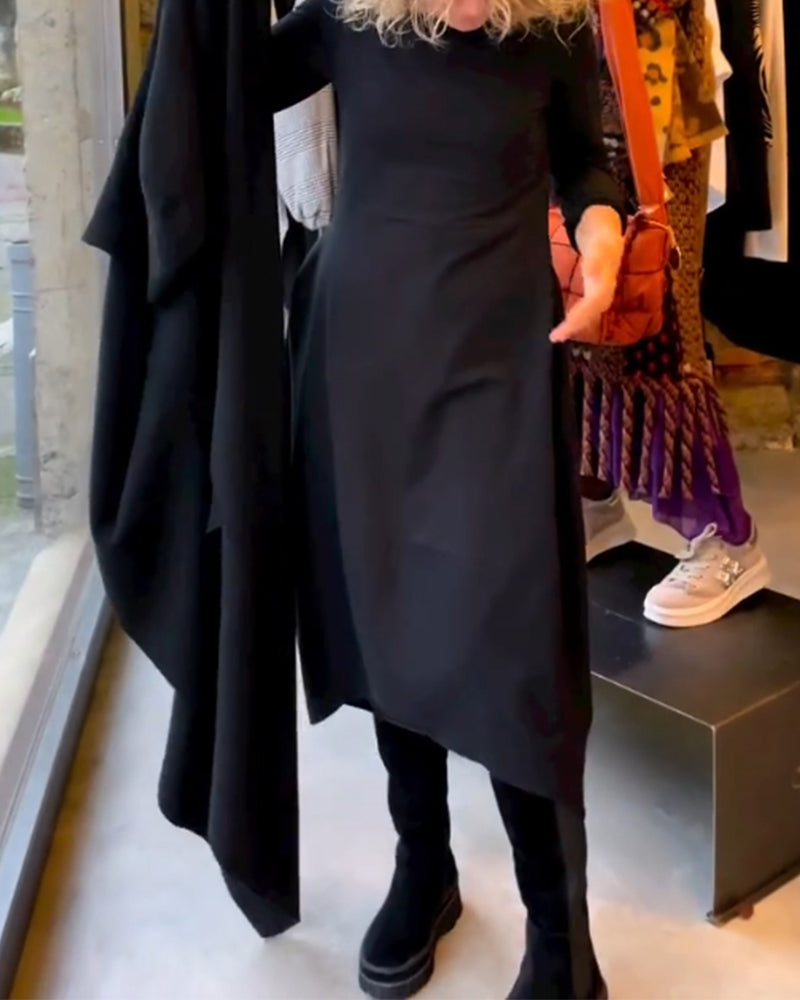 Frau in schwarzem asymmetrischem Kleid, schwarze Stiefel, Modegeschäft, moderne Damenmode.