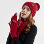 Frau mit roter Strickmütze, Schal und Handschuhen, Wintermode, warm, stilvoll.