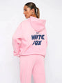Frau in rosa Hoodie und Jogginghose mit "White Fox" Aufdruck, lässige Damenmode.