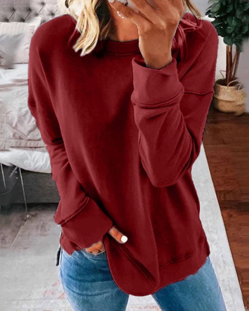 Frau in rotem Pullover, Jeans, gemütliches Wohnzimmer, Mode, Freizeitkleidung, Herbststil.