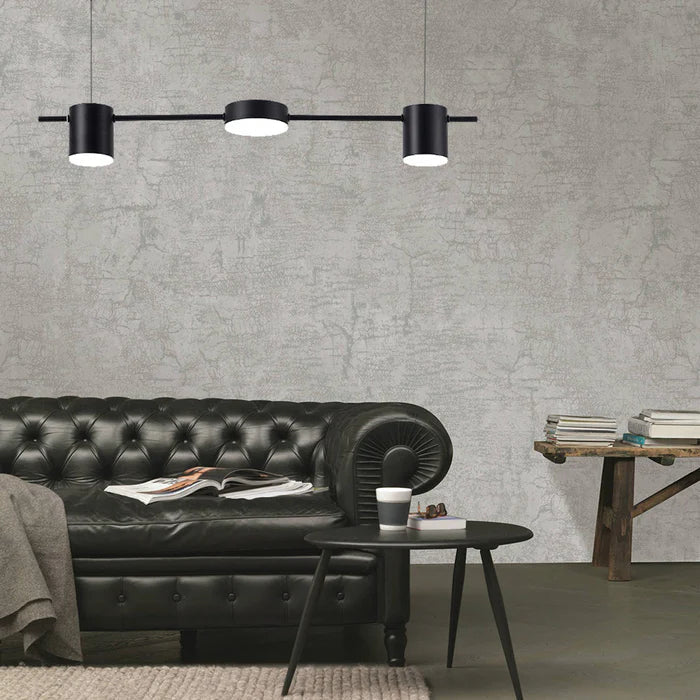 Schwarzes Ledersofa mit Couchtisch und moderner Hängelampe in minimalistischem Wohnzimmer.