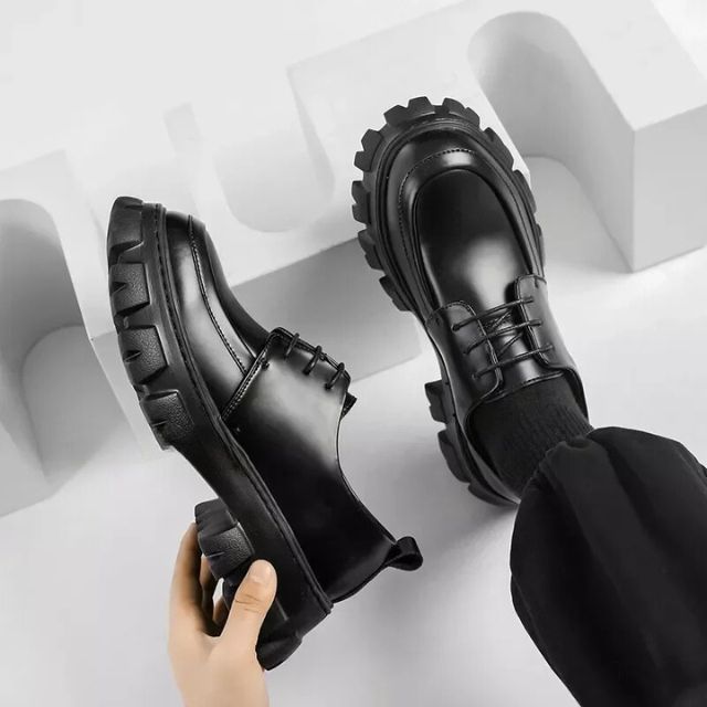 Schwarze Leder-Loafer mit dicker Sohle, modische Herrenschuhe, elegantes Design.