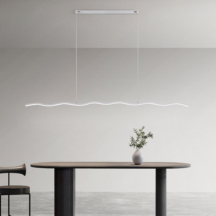 Moderne LED-Pendelleuchte, wellenförmig, weiß, über Esstisch, minimalistisches Design.