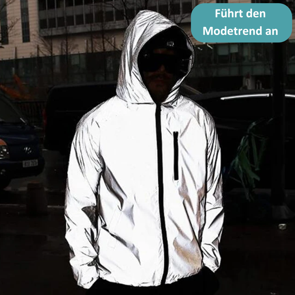 Mann in reflektierender Jacke mit Kapuze, modisch, urbaner Stil, Nachtaufnahme.
