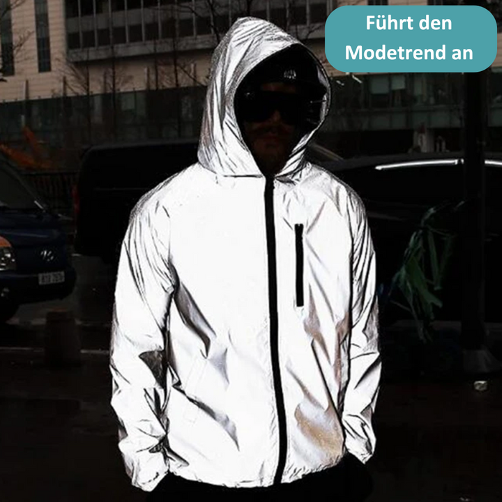 Mann in reflektierender Jacke mit Kapuze, modisch, urbaner Stil, Nachtaufnahme.