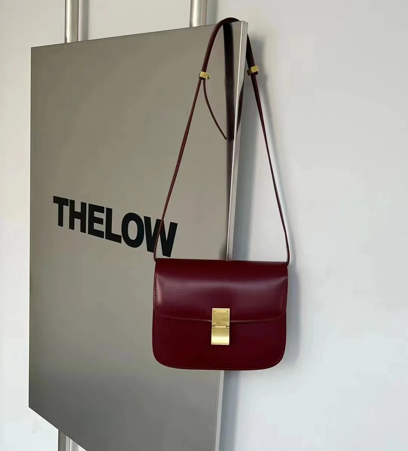 Bordeauxrote Ledertasche mit goldener Schnalle, Umhängetasche, elegantes Design, Damenmode.