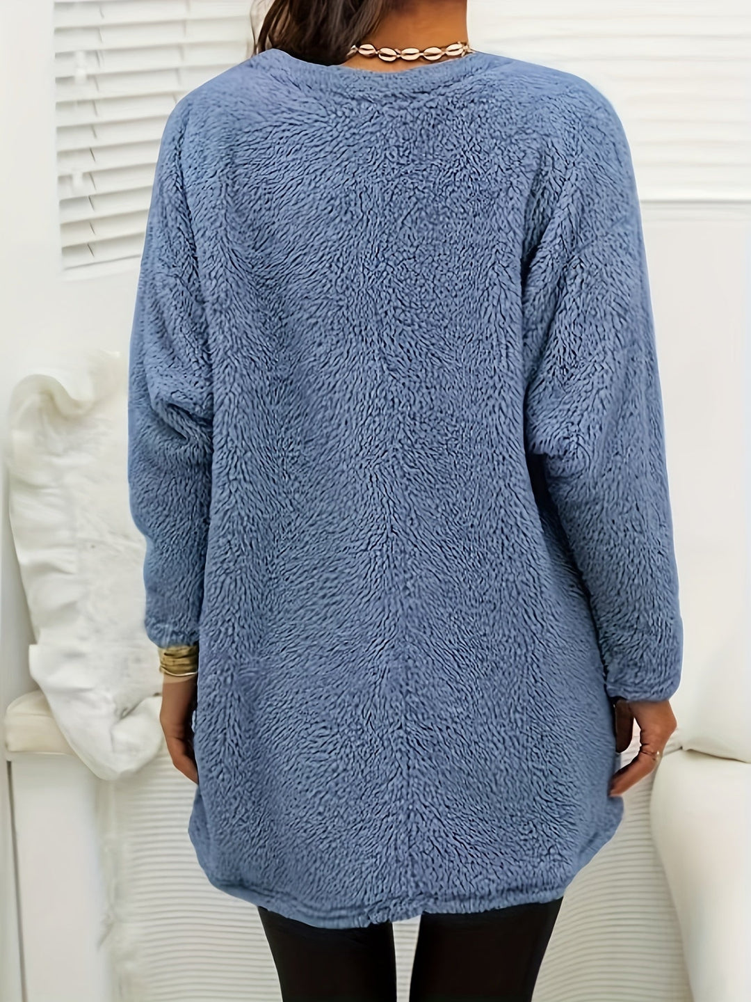Frau in blauem Fleece-Pullover, Rückansicht, gemütlich, modisch, Winterkleidung.