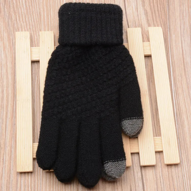 Schwarzer Strickhandschuh mit Touchscreen-Fingerspitzen auf Holzuntergrund.
