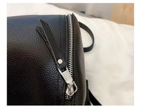 Schwarzer Lederrucksack mit silbernem Reißverschluss auf weißem Hintergrund.