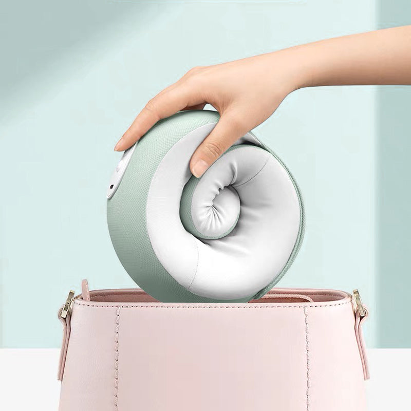 Hand legt grünes, faltbares Nackenkissen in rosa Tasche, Reiseaccessoire, ergonomisch.