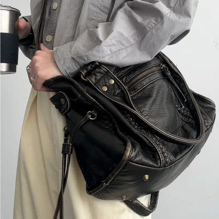 Damenhandtasche aus schwarzem Leder, lässiger Stil, mit Reißverschluss und Nieten, modisch.
