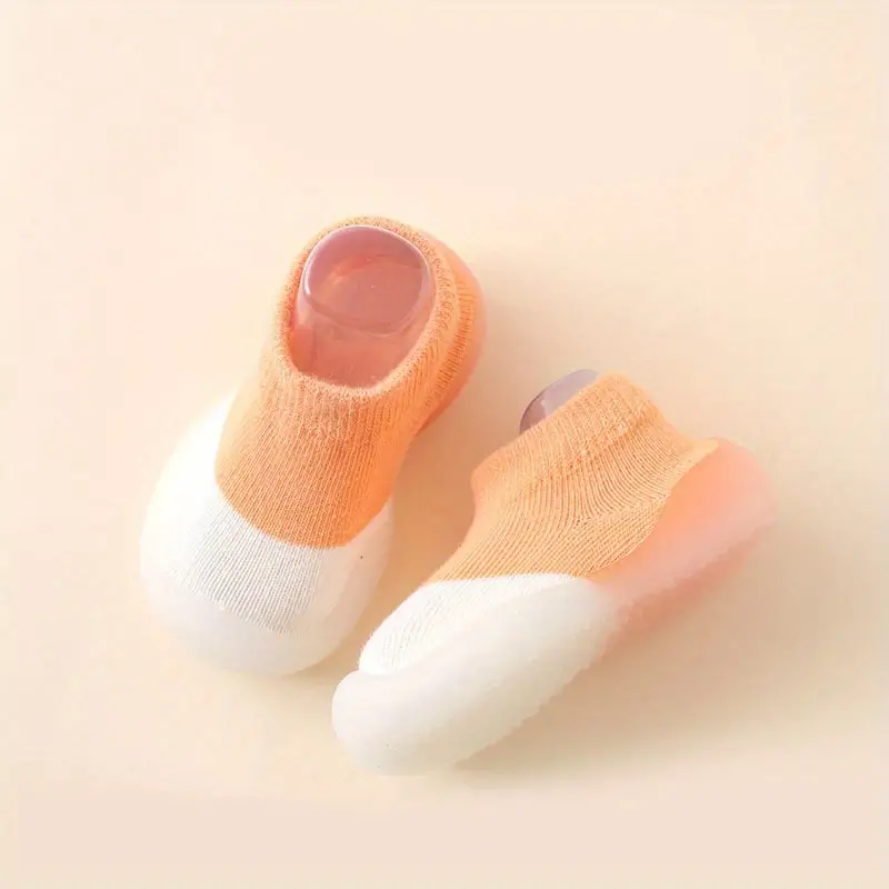 Orange-weiße Babyschuhe aus Baumwolle mit rutschfester Sohle, ideal für Kleinkinder.