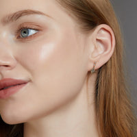 Frau mit goldenen Ohrringen, Nahaufnahme, Schmuck, Modeaccessoire, elegantes Design.