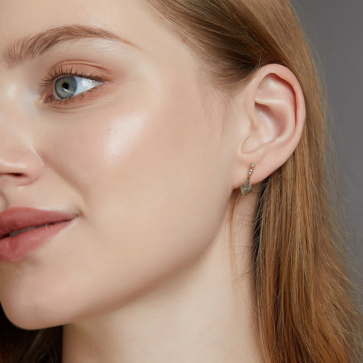 Frau mit goldenen Ohrringen, Nahaufnahme, Schmuck, Modeaccessoire, elegantes Design.