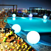Luxuriöser Hotelpool bei Nacht mit leuchtenden Kugeln und elegantem Buffet im Vordergrund.