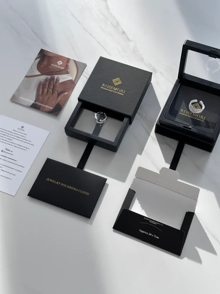 Schwarzer Schmuckkarton mit Ring, Rosimori-Logo, Schmuckpoliertuch, elegantes Design.