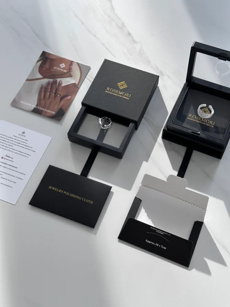 Schwarzer Schmuckkarton mit Ring, Rosimori-Logo, Schmuckpoliertuch, elegantes Design.
