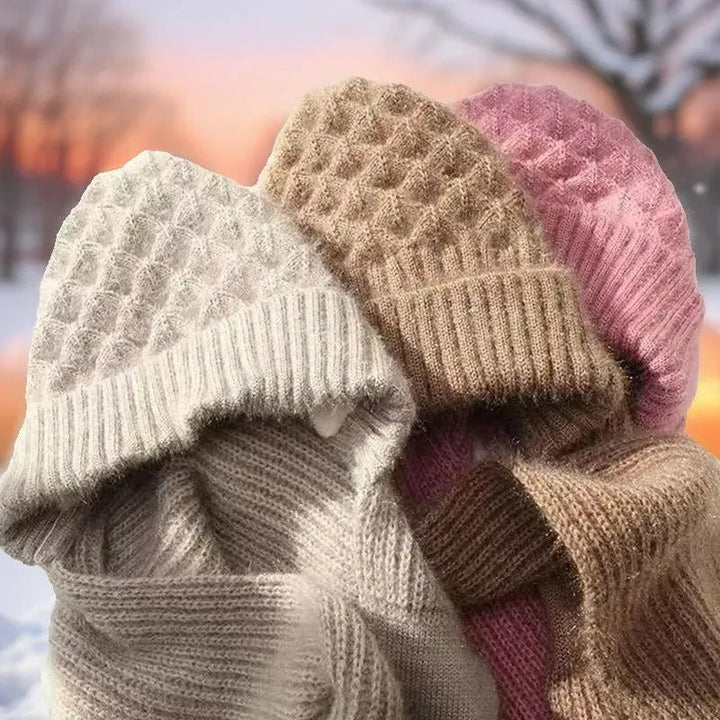 Drei gestrickte Wintermützen in Beige, Rosa und Weiß, warm und stilvoll für kalte Tage.