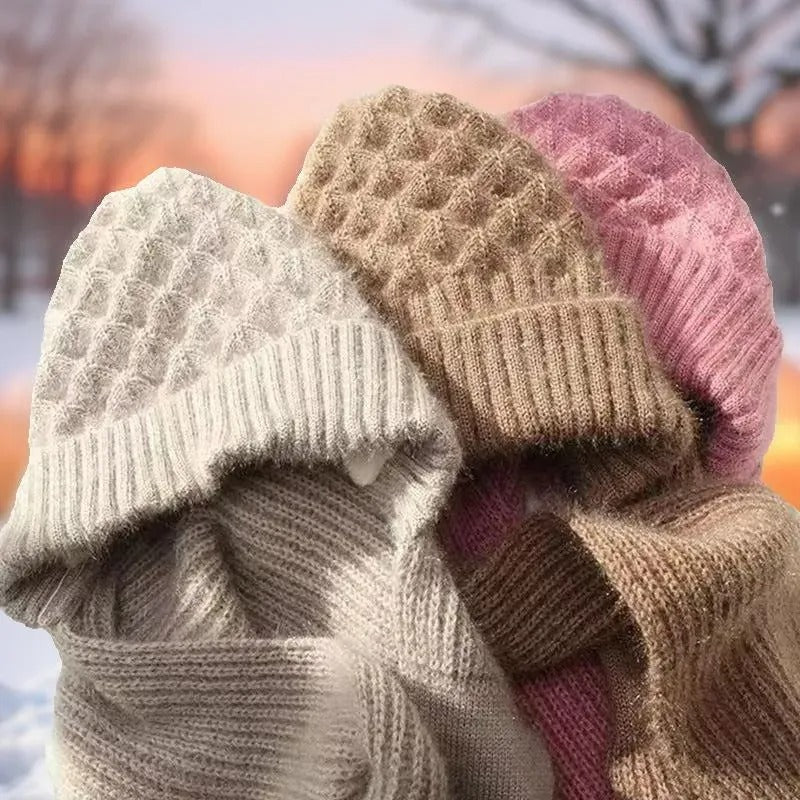 Drei gestrickte Wintermützen in Beige, Rosa und Weiß, warm und stilvoll für kalte Tage.
