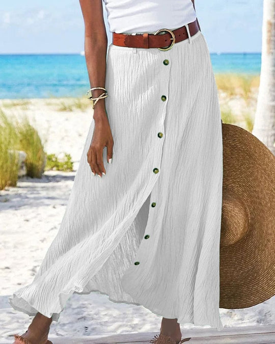 Frau in weißem Maxirock mit Knöpfen am Strand, Sommermode, Damenbekleidung, Urlaub.