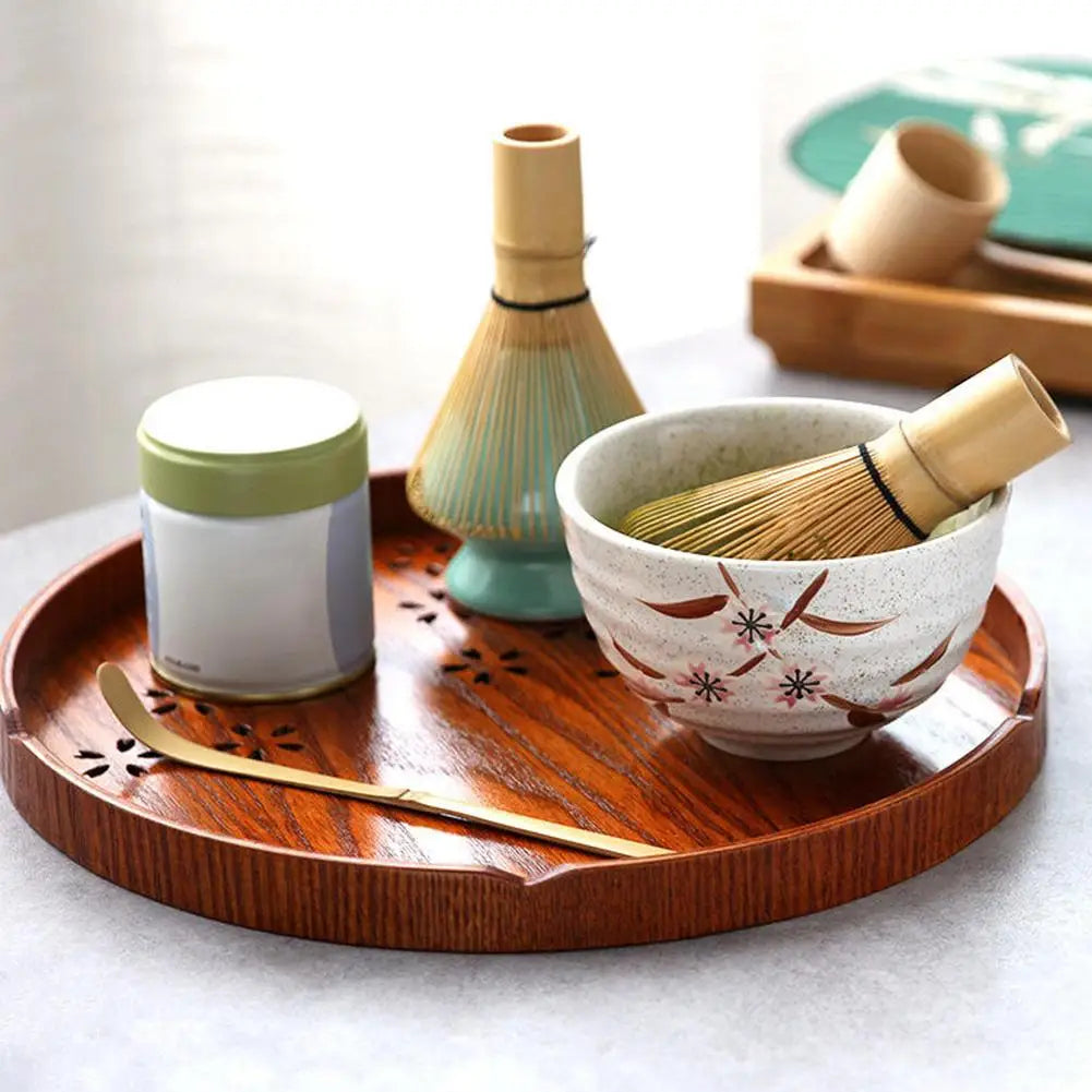 Matcha-Set auf Holztablett: Schale, Bambusbesen, Teedose, Bambuslöffel, japanische Teezeremonie.