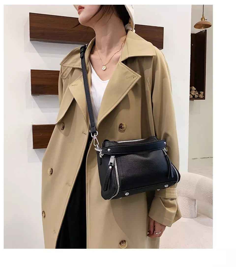 Frau mit beigem Trenchcoat und schwarzer Ledertasche, modisch, elegant, Herbstmode.