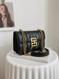 Schwarze Lederhandtasche mit goldener Kette, elegantes Design, Damenmode Accessoire.