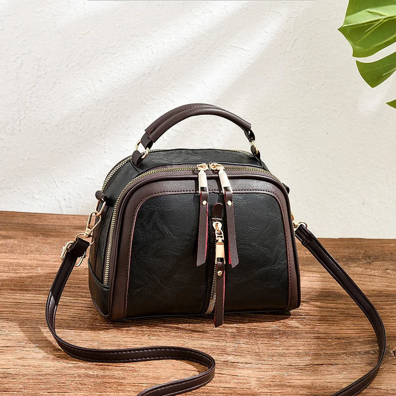 Schwarze Lederhandtasche mit Reißverschluss, verstellbarem Riemen, elegant, Damenmode.