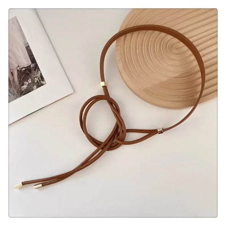 Brauner Ledergürtel mit goldenen Akzenten auf hellem Hintergrund, modisches Accessoire.