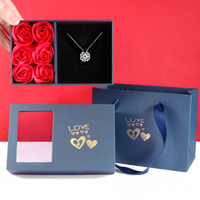 Blaue Geschenkbox mit Rosen und Schmetterlingskette, ideal für Valentinstag, Liebe, Romantik.
