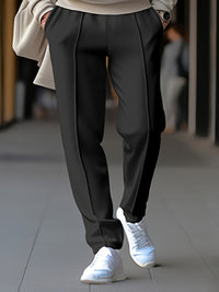 Elegante schwarze Hose, Damenmode, kombiniert mit weißen Sneakers, stilvoller Look.