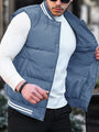 Mann in blauer Steppweste und weißem Pullover, modisch, lässig, Outdoor-Bekleidung.