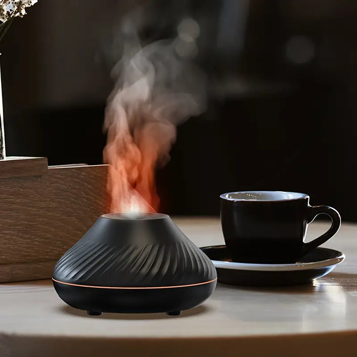 Schwarzer Aromadiffuser mit Dampf, modernes Design, auf Holztisch neben schwarzer Tasse.
