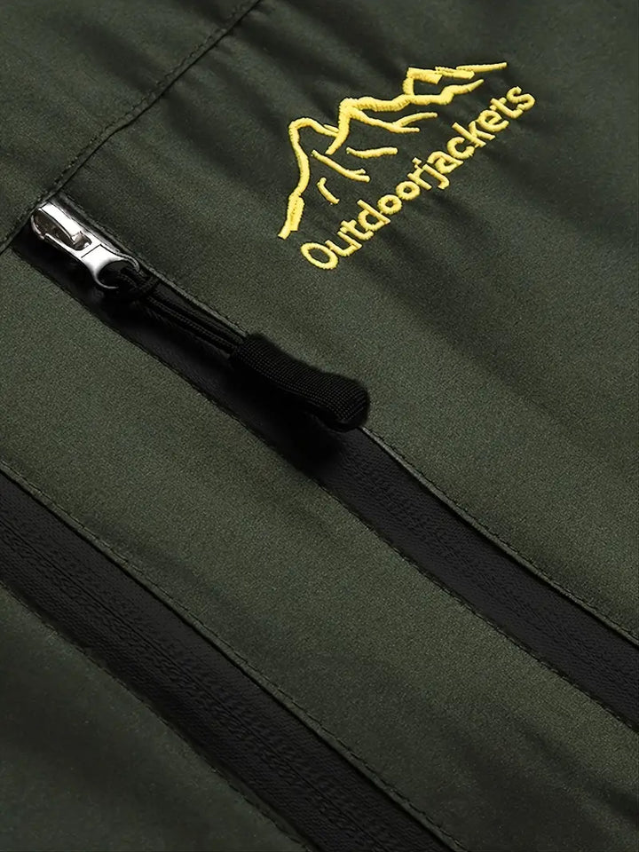 Grüne Outdoorjacke mit Reißverschluss und gelbem Logo, ideal für Wandern und Trekking.