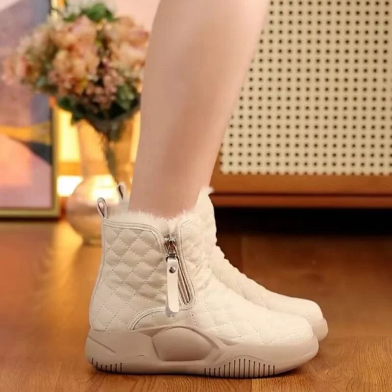 Weiße Damen-Winterstiefel mit Reißverschluss, gesteppt, warm gefüttert, auf Holzboden.