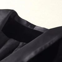 Schwarzes Seidenkleid, elegantes Design, Nahaufnahme, luxuriöser Stoff, Modekleidung.