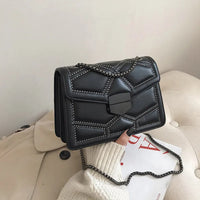 Schwarze Lederhandtasche mit Nieten, Kettengurt, elegantes Design, Damenmode Accessoire.