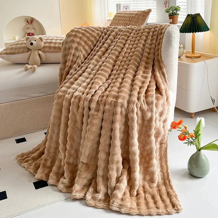 Beige Kuscheldecke aus Kunstfell auf Sofa, gemütliches Wohnzimmer, moderne Inneneinrichtung.