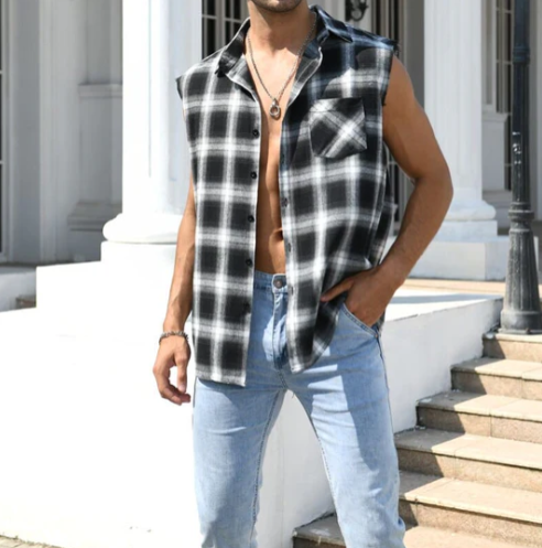 Mann in ärmellosem schwarz-weiß kariertem Hemd und blauer Jeans vor Gebäude.