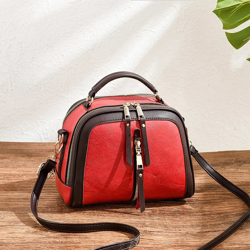 Rote Damenhandtasche aus Leder mit braunen Akzenten, Umhängetasche, modisch, elegant.