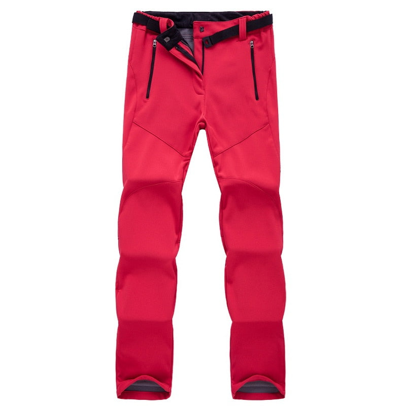 Rote Outdoor-Hose, wasserdicht, mit Reißverschlusstaschen, ideal für Wandern und Trekking.