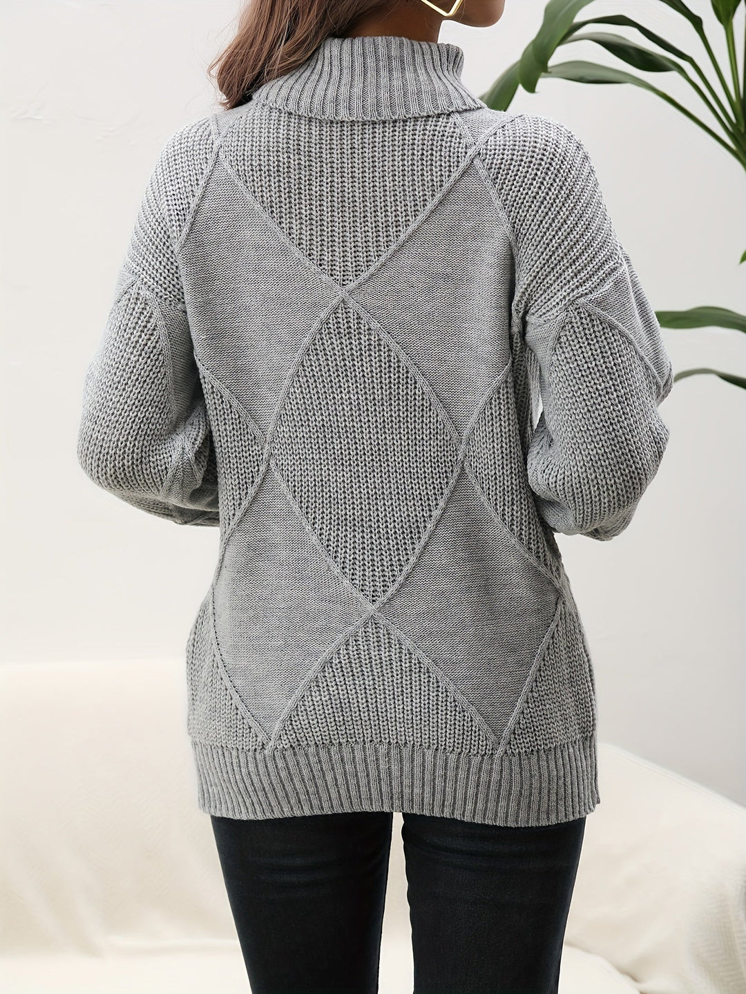 Frau in grauem Strickpullover mit Rautenmuster, Rollkragen, Herbstmode, Rückansicht.