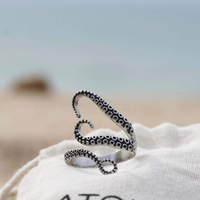 Silberner Kraken-Tentakel-Ring am Strand, handgefertigter Schmuck, maritimes Design.