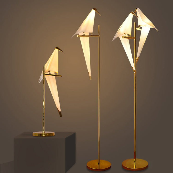 Drei goldene Stehlampen in Vogel-Design, modern, elegant, warmweißes Licht.